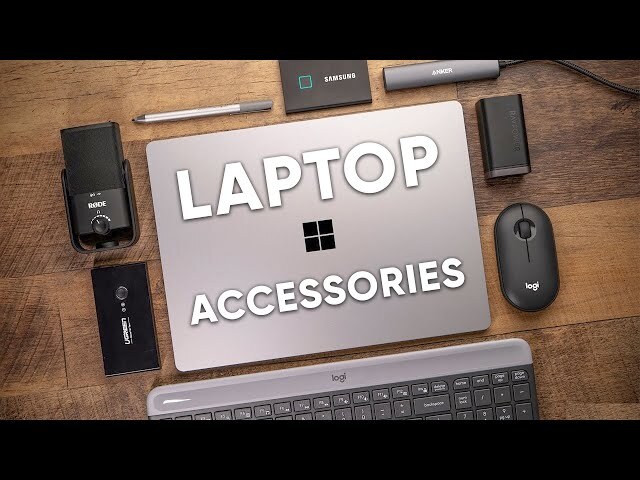 "Flat lay of a laptop with essential accessories, including headphones, mouse, USB hub, external hard drive, power adapter, eyeglasses, and cables, arranged on a neutral background."