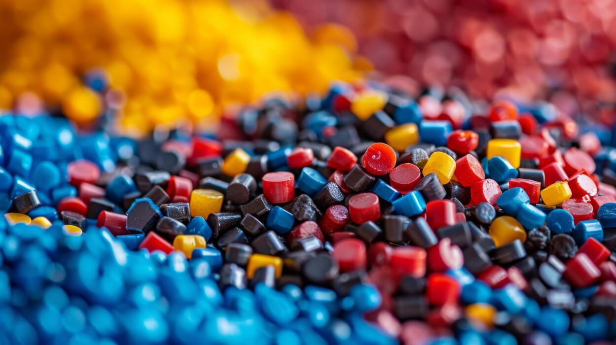 Colored polymer granules used in artificial turf fiber production, showcasing raw material base for high-performance synthetic grass systems