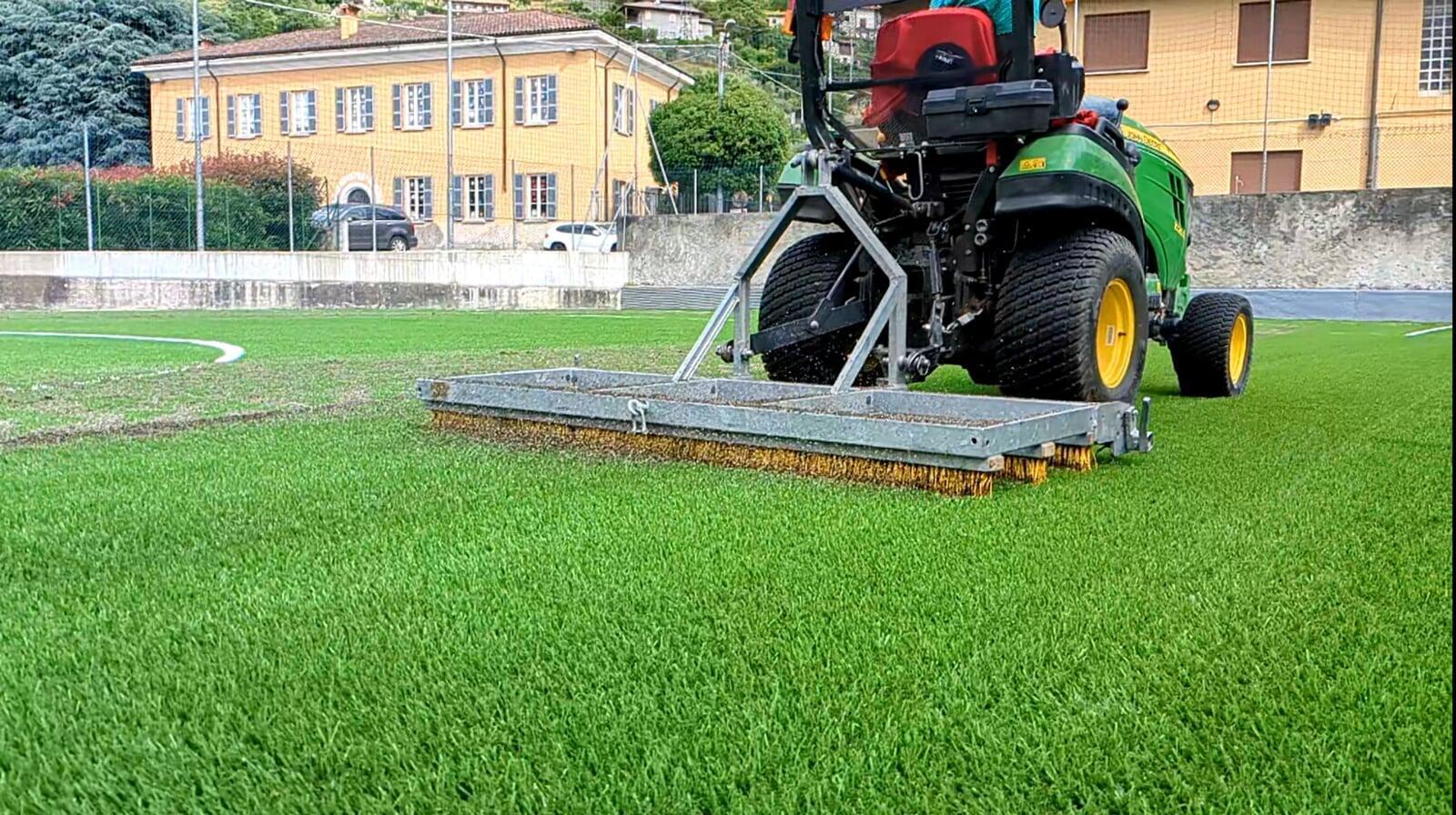 Professional machine grooming artificial turf field surface for improved performance, durability and even fibre distribution on sports turf Professional machine grooming artificial turf field surface for improved performance, durability and even fibre distribution on sports turf