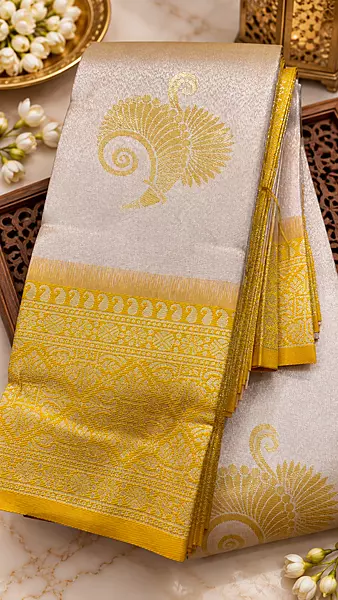 Gorgeous ivory-white body with delicate golden peacock motifs with Rich mustard-gold zari border with intricate traditional designs