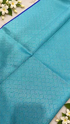 A gorgeous Turquoise Blue Semi Soft Silk Saree featuring an elegant all-over geometric jacquard weave that adds a subtle, luxurious texture to the fabric.