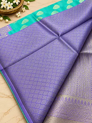A graceful Lavender Purple Semi Soft Silk Saree featuring a delicate all-over geometric zari weave that creates a rich, textured look with a beautiful subtle sheen.