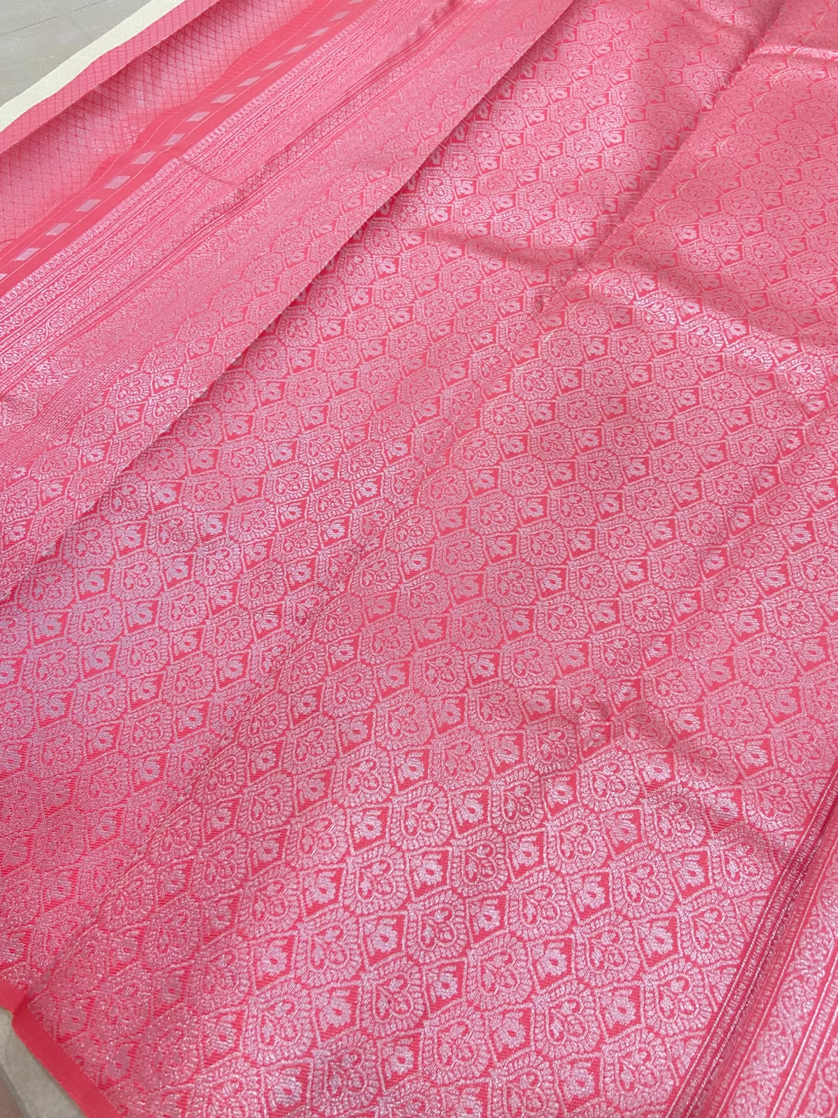 stunning ivory-gold Tissue Silk Saree featuring delicate pink paisley motifs beautifully scattered across the body.
