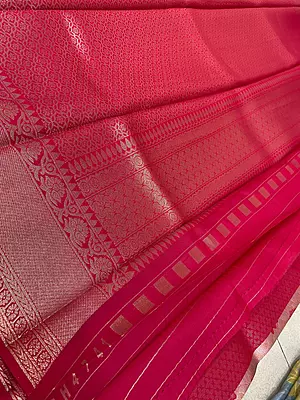 gorgeous coral pink silk saree featuring elegant floral motifs beautifully woven across the body