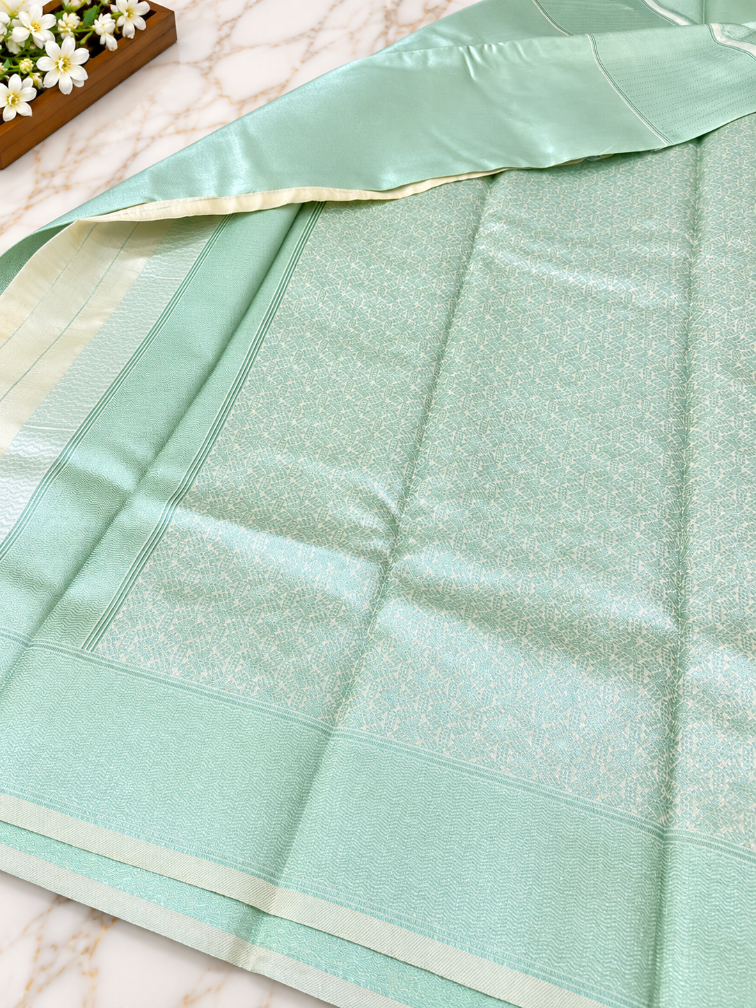 ? Mint Green Silk Saree A stunning mint green silk saree featuring an elegant all-over woven geometric jacquard pattern with a subtle metallic sheen