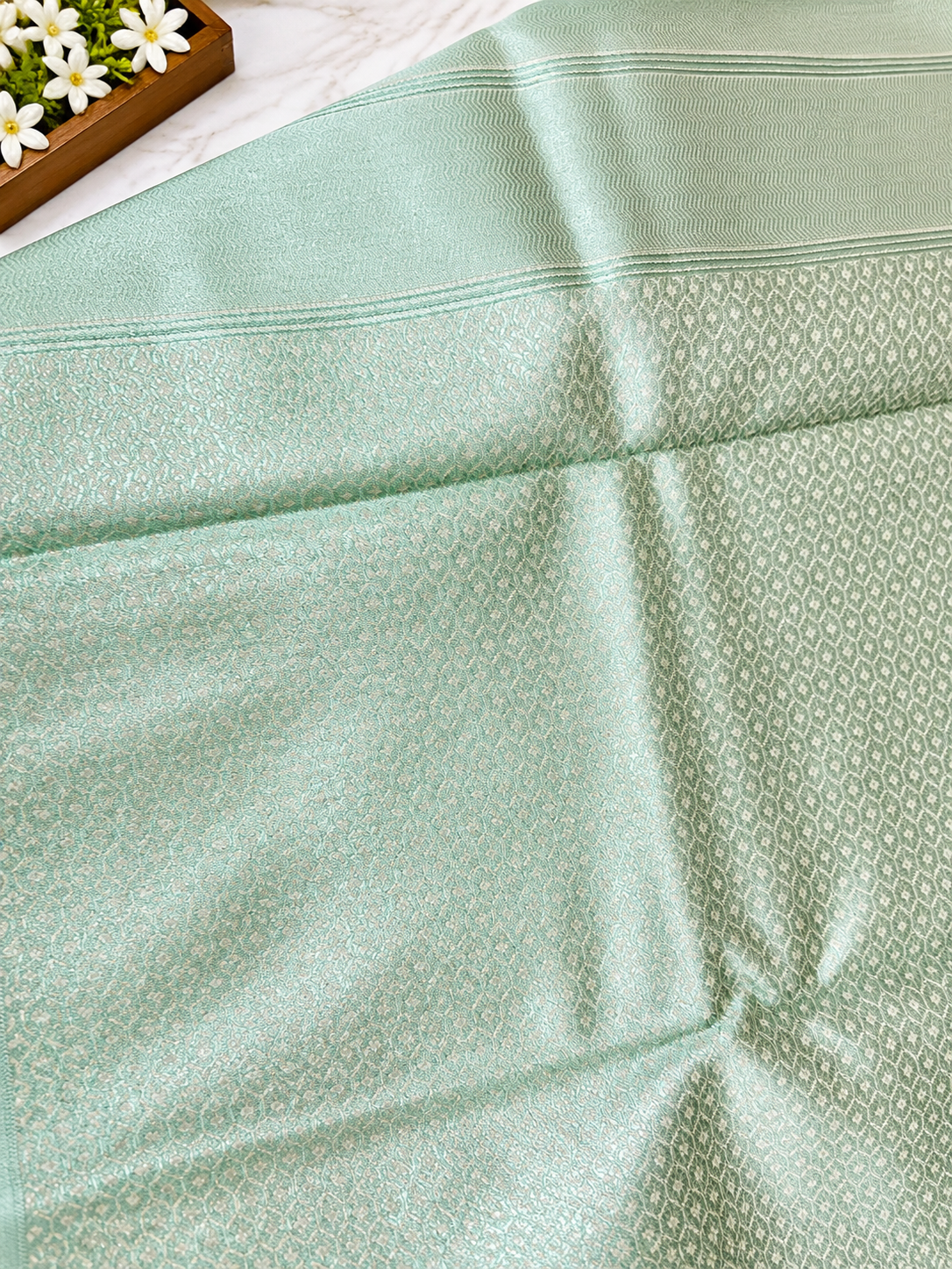 ? Mint Green Silk Saree A stunning mint green silk saree featuring an elegant all-over woven geometric jacquard pattern with a subtle metallic sheen