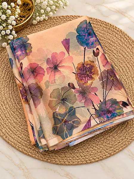 A dreamy peach saree adorned with vibrant watercolor-inspired florals in beautiful pastel and jewel tones — a perfect blend of elegance, freshness and effortless style?