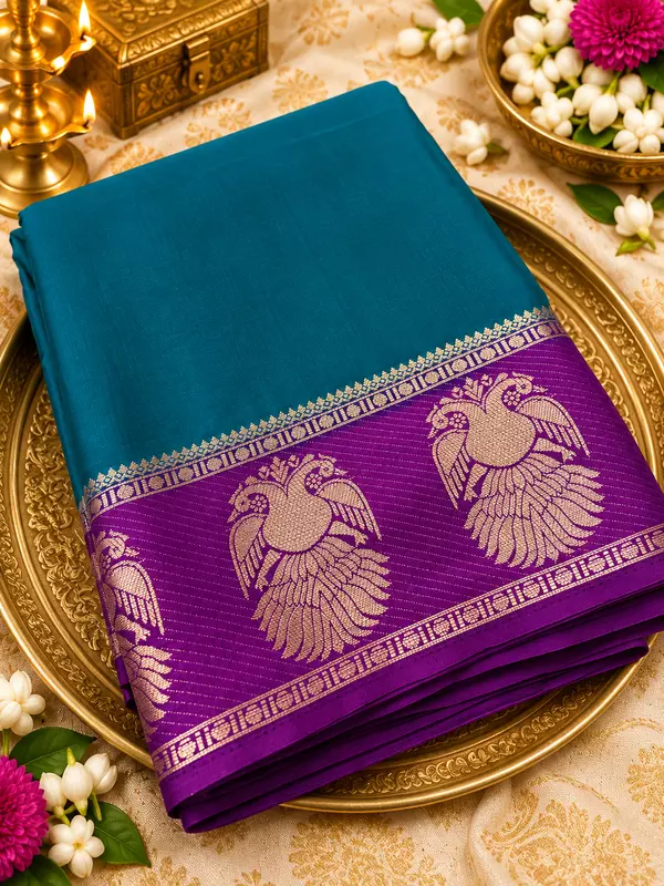? ROYAL PURPLE SILK SAREE A stunning royal purple silk saree featuring intricate gold zari weaving, elegant peacock motifs, and a beautifully detailed geometric floral pattern.