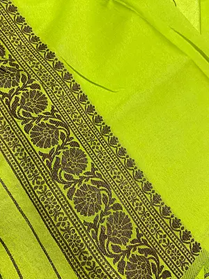 : This stunning light lime-green art silk saree is a perfect blend of traditional charm and contemporary style