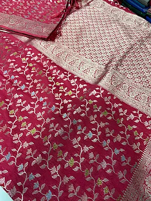 A gorgeous rani pink silk saree featuring an all-over delicate woven vine and floral creeper pattern in shimmering silver and pastel threads.