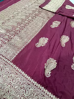 A deep maroon silk saree featuring scattered large, elegant silver-gold zari paisley motifs across the body