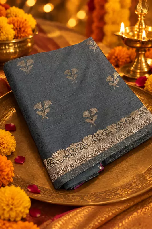 A sophisticated slate grey silk saree featuring delicate silver zari floral buttas scattered beautifully across the body.