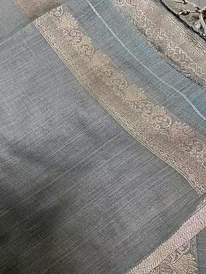 A sophisticated slate grey silk saree featuring delicate silver zari floral buttas scattered beautifully across the body.