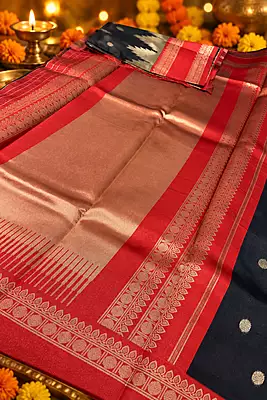 A striking navy blue and vibrant red silk saree featuring elegant gold zari polka buttas across the deep navy body