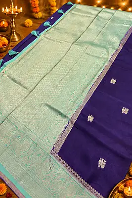 A gorgeous royal purple silk saree featuring delicate gold zari paisley buttas beautifully scattered across the body.