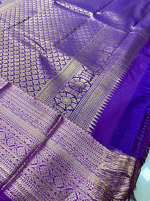 ? Peach & Purple Silk Saree – Description A graceful peach silk saree featuring delicate gold zari floral buttas scattered elegantly across the body.