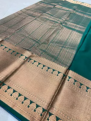 A graceful powder blue silk saree featuring elegant antique-gold paisley motifs scattered across the body.