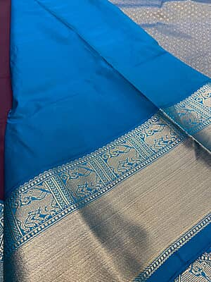 A rich deep wine silk saree featuring elegant vertical gold zari stripe detailing