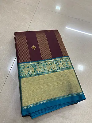 A rich deep wine silk saree featuring elegant vertical gold zari stripe detailing