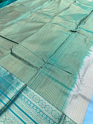 A refreshing sky blue silk saree beautifully paired with a rich teal green contrast border.