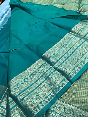 A refreshing sky blue silk saree beautifully paired with a rich teal green contrast border.