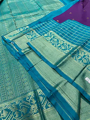 A gorgeous deep purple silk saree featuring delicate gold zari buttas scattered elegantly across the body.