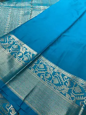 A gorgeous deep purple silk saree featuring delicate gold zari buttas scattered elegantly across the body.