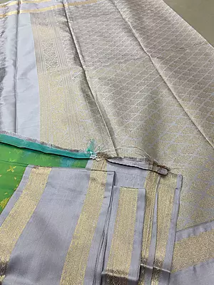 A graceful pistachio green silk saree adorned with delicate gold zari floral and butta motifs scattered beautifully across the body