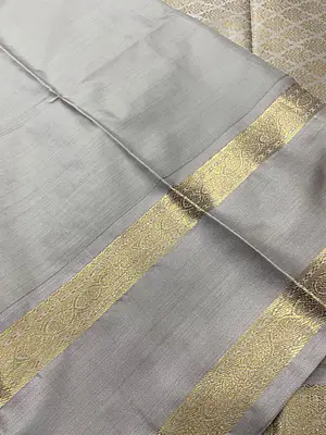 A graceful pistachio green silk saree adorned with delicate gold zari floral and butta motifs scattered beautifully across the body