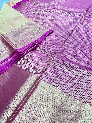 A luxurious peach-gold silk saree with a beautiful lustrous finish, adorned with delicate gold zari buttas and elegant floral motifs