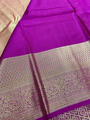 A luxurious peach-gold silk saree with a beautiful lustrous finish, adorned with delicate gold zari buttas and elegant floral motifs