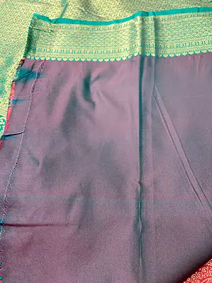 A rich red and teal silk saree featuring an intricate all-over gold zari floral pattern on the body.