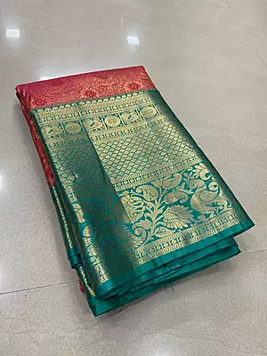 A rich red and teal silk saree featuring an intricate all-over gold zari floral pattern on the body.
