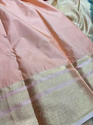 A sophisticated deep navy blue silk saree adorned with fine gold zari checks and traditional motifs.
