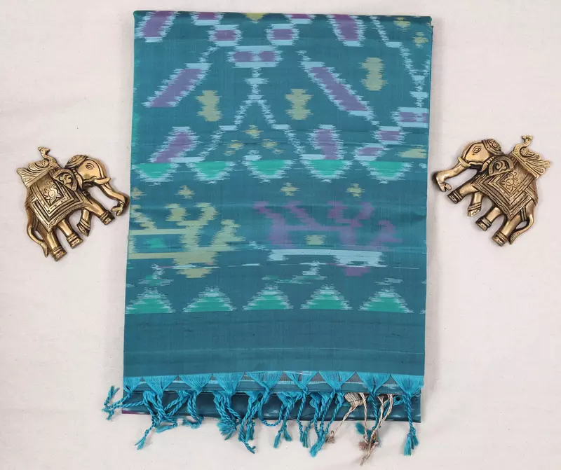 Teal blue silk saree with circular motifs, multicolour ikat pallu, and ikat blouse.