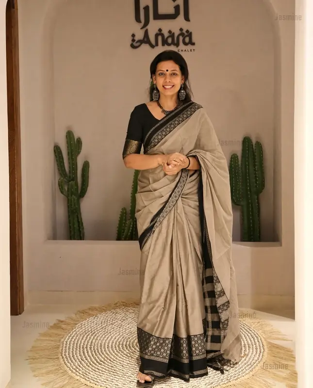 Mercerised cotton saree with soft texture, subtle shine and detailed black floral border