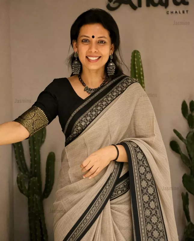 Ash grey cotton saree with a plain body and contrasting black floral border