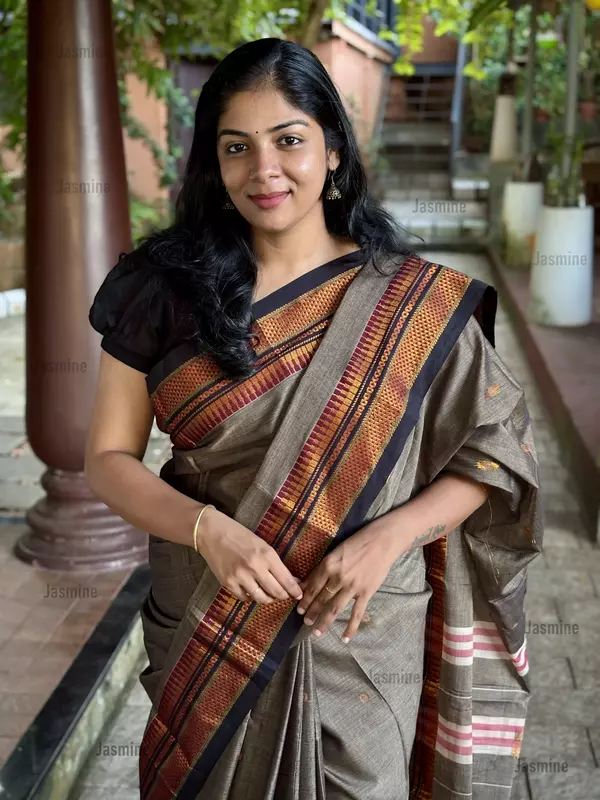 Ash grey cotton saree with black contrast border and delicate thread-woven buttas across the body