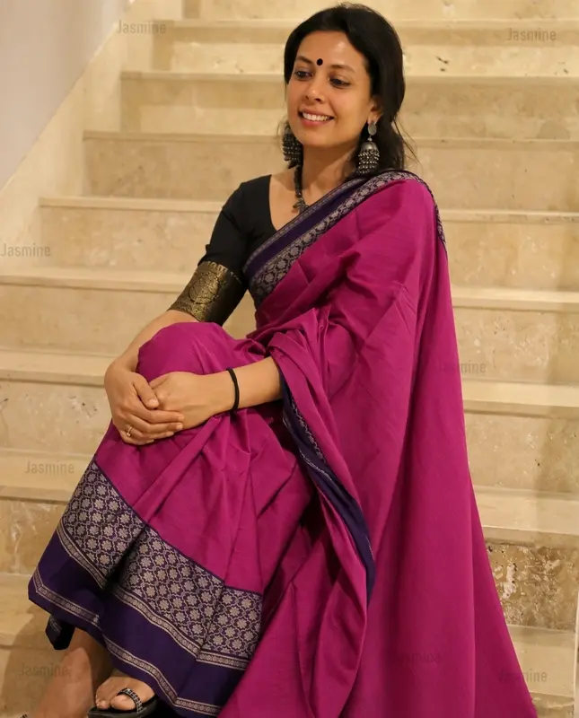 Magenta cotton saree with a plain body and contrasting dark blue floral design border