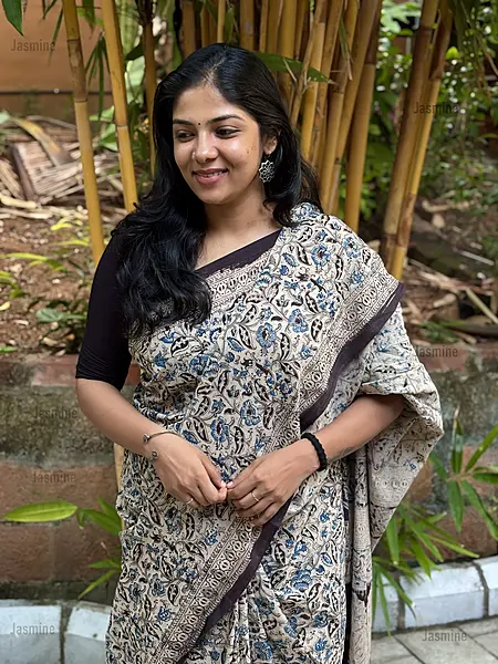 White cotton saree featuring simple blue and black floral prints with a contrast border
