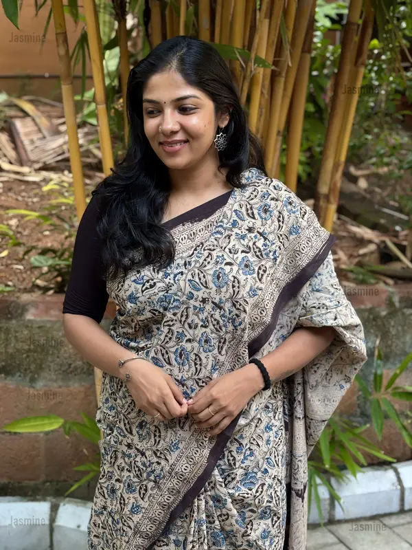 White cotton saree featuring simple blue and black floral prints with a contrast border