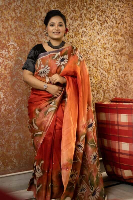 Rust Orange color pure Mulberry silk with flower hand batik motif saree from our Mystic Radainave collection