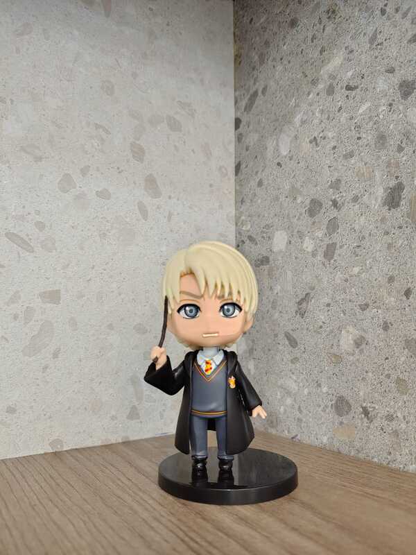 Draco Malfoy holding his wand