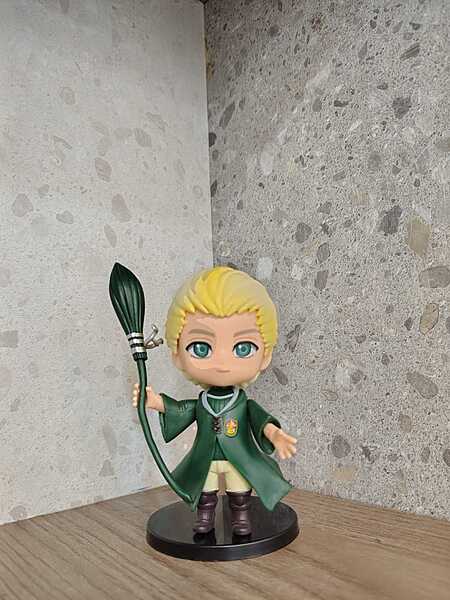 Draco Malfoy holding his  wand