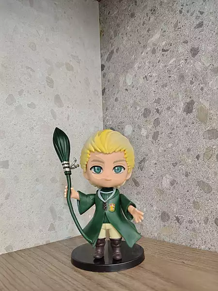 Draco Malfoy holding his wand