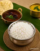 Fluffy cooked Bodhana rice in bronze bowl with curry leaves.