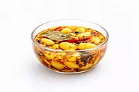 Garlic chilli pickle in glass bowl on white background