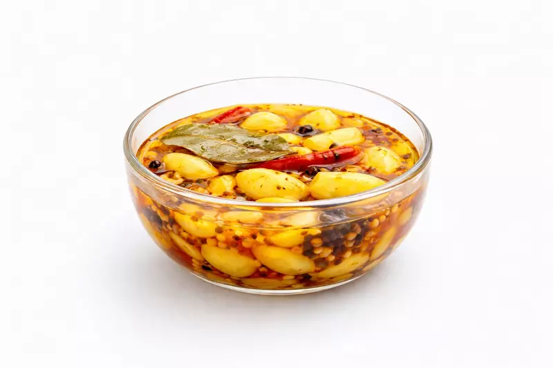 Garlic chilli pickle in glass bowl on white background