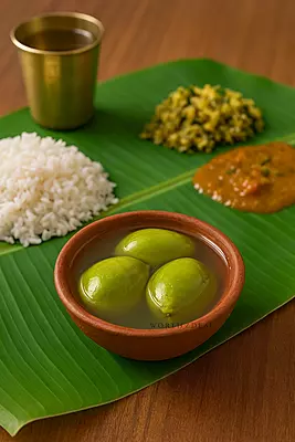 Clay bowl filled with Kerala salted mango (uppu manga) photographed on banana lead with rice