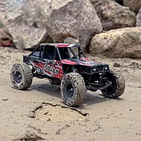 Red LDRC Model 18499R crawling over rough rocks demonstrating solid axle suspension articulation